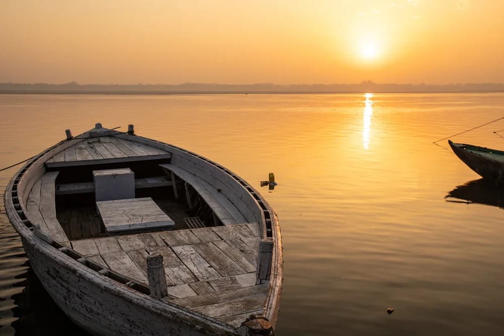 Wooden boat moored on the River Ganga in golden light at Varanasi