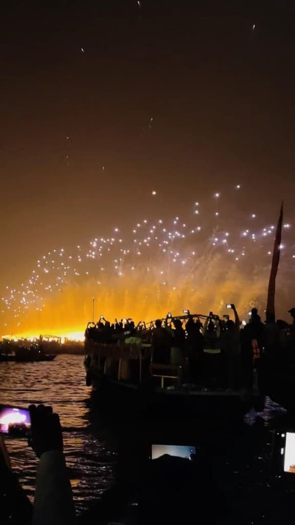 Silhouetted boat on the Ganga as fireworks burst over the Varanasi riverfront on Dev Deepawali night